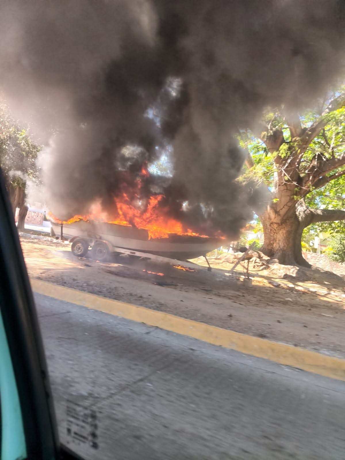 Lancha envuelta por el fuego y humo negro