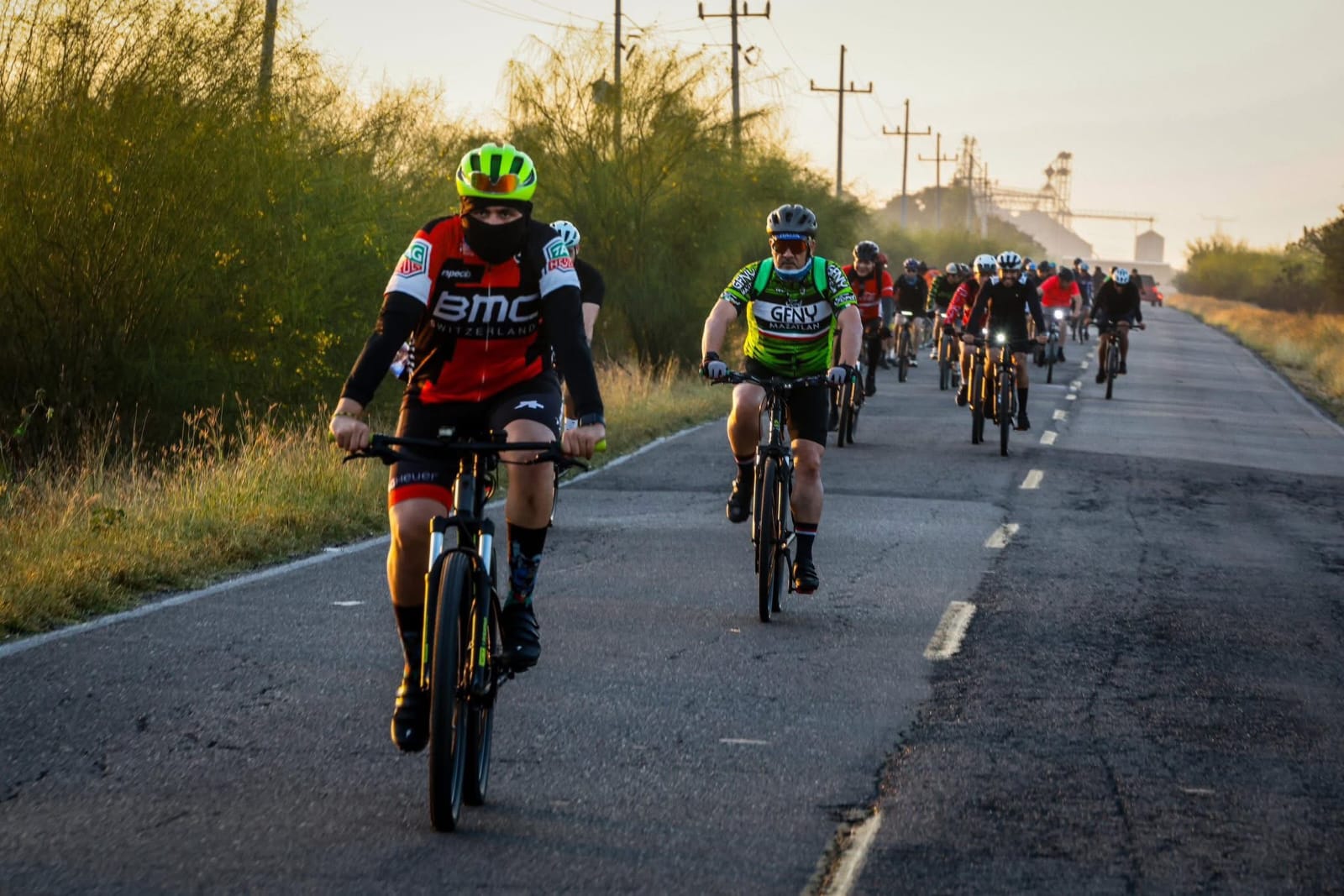 Ciclistas transitando por carretera en grupo
