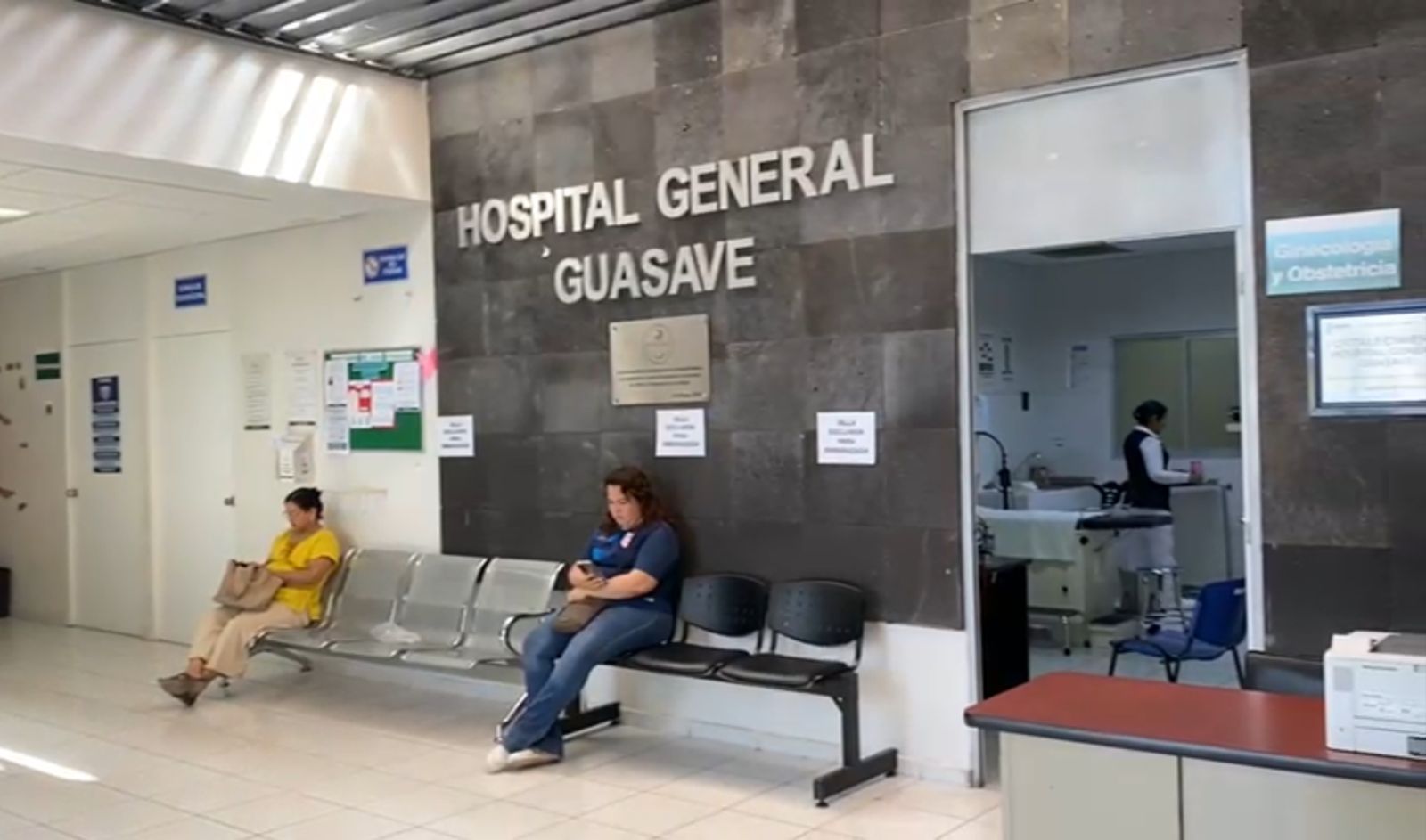 Sala de espera en el Hospital General de Guasave con dos personas sentadas