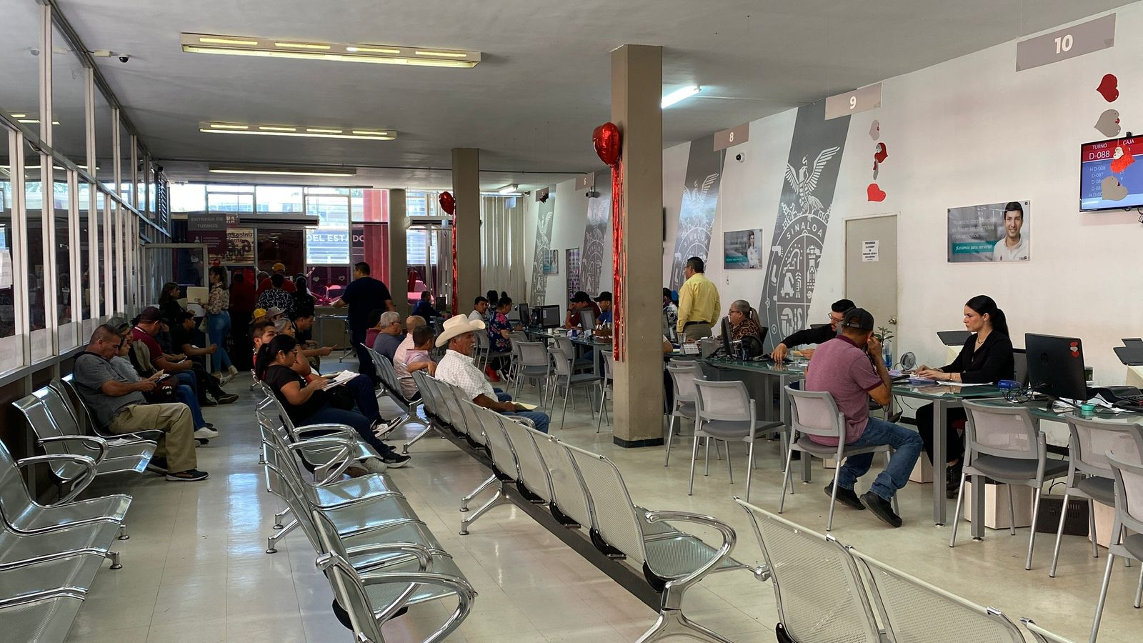 Oficinas de SATES con muchas personas en módulos con cristales