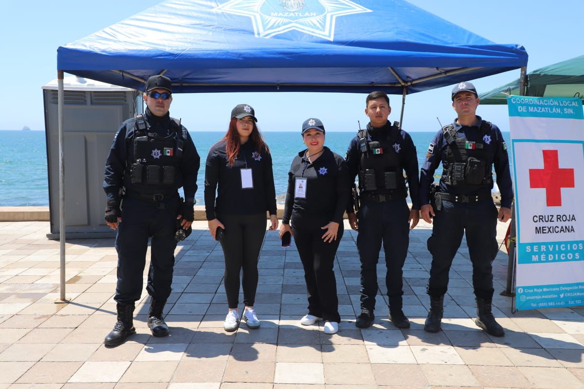 Cinco elementos de la Policía Municipal frente a una carpa en el malecón