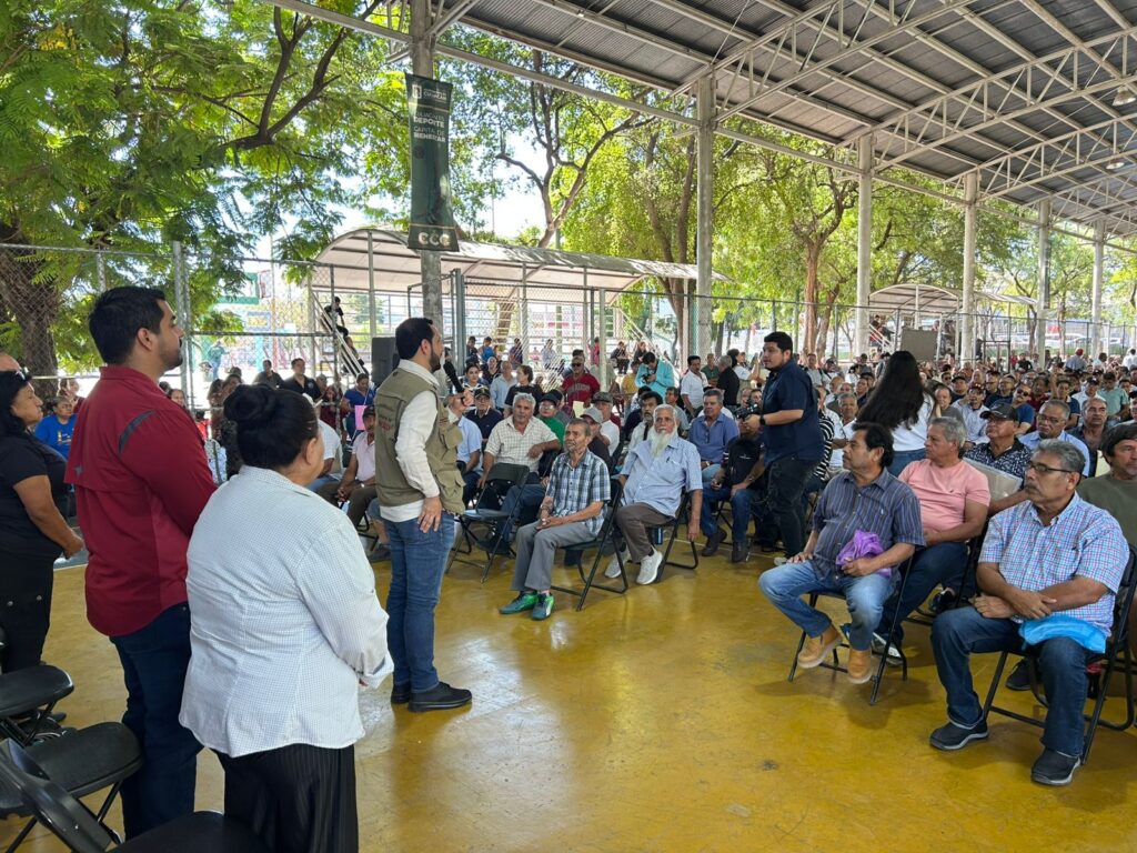 Adultos mayores sentados en la explanada en el parque constitución