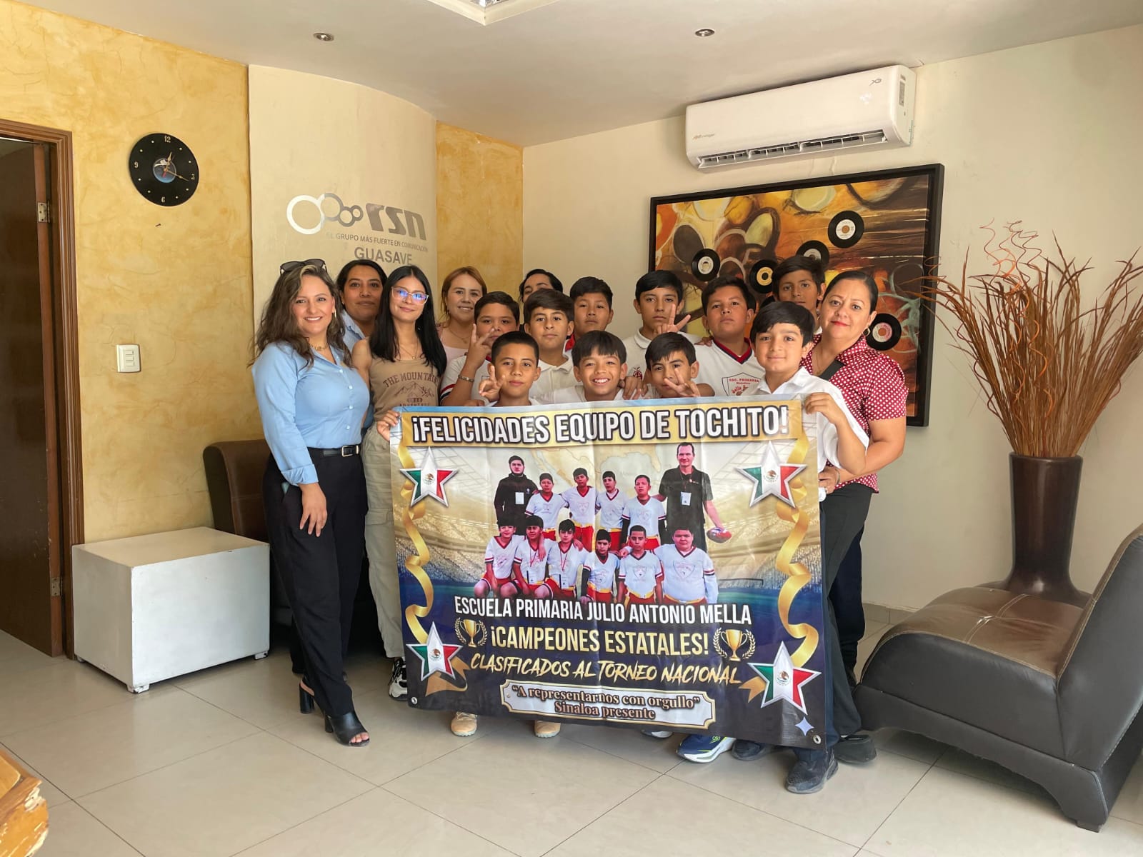 Niños con lona y Mujeres posando para foto