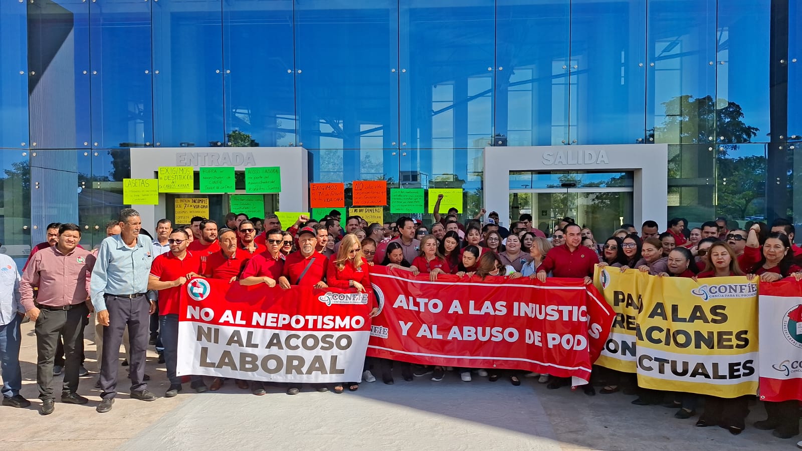 Trabajadores del Centro de Ciencias de Sinaloa sosteniendo pancartas afuera de la institución