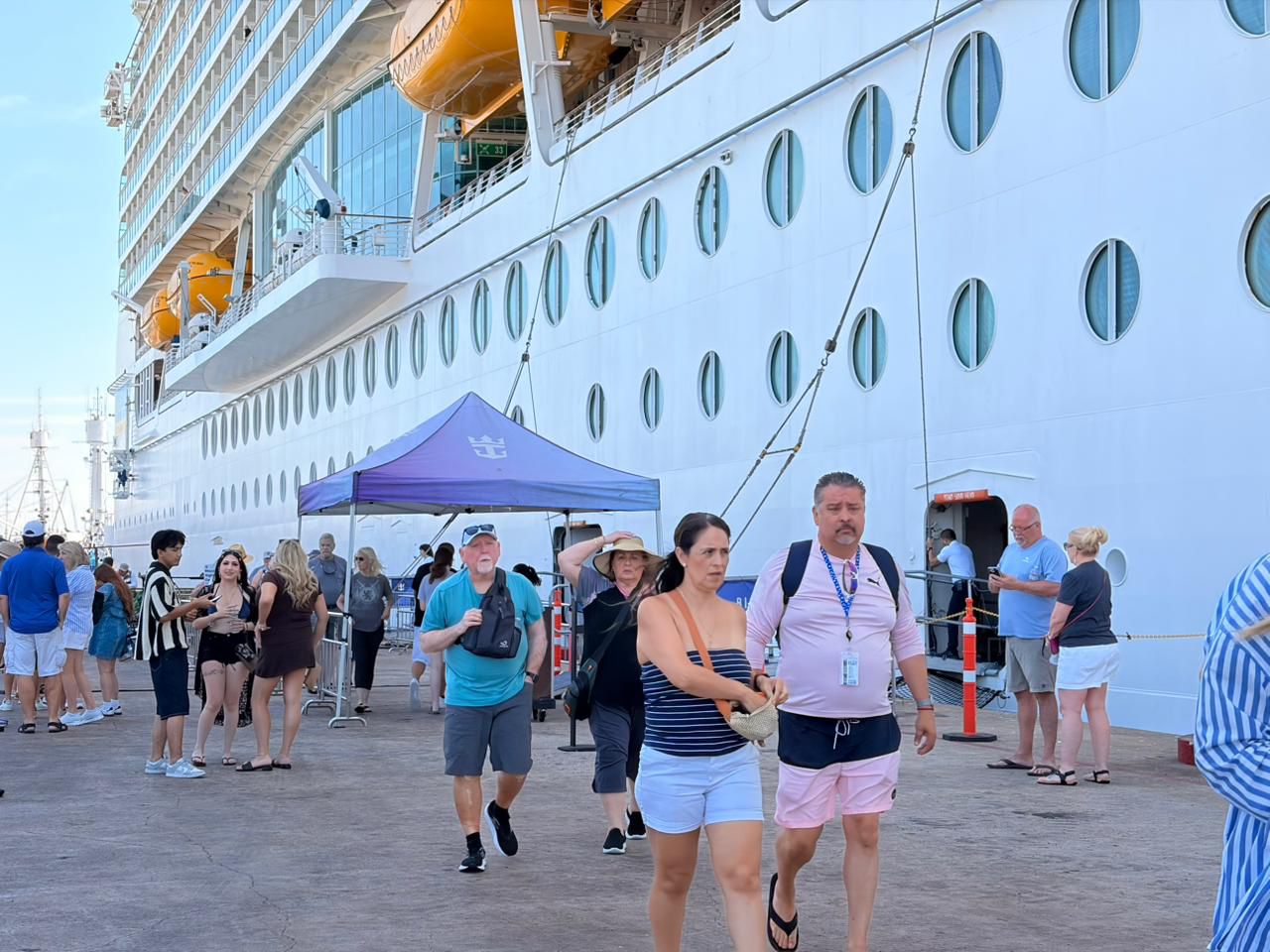 turistas caminando y crucero detrás de ellos