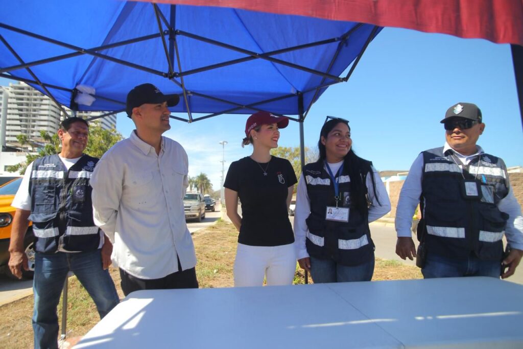 Cinco personas de seguridad en la playa con la alcaldesa de Mazatlán