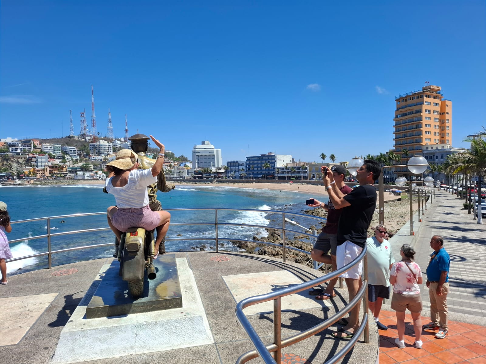 Turistas disfrutando de los paisajes y monumentos en Mazatlán.