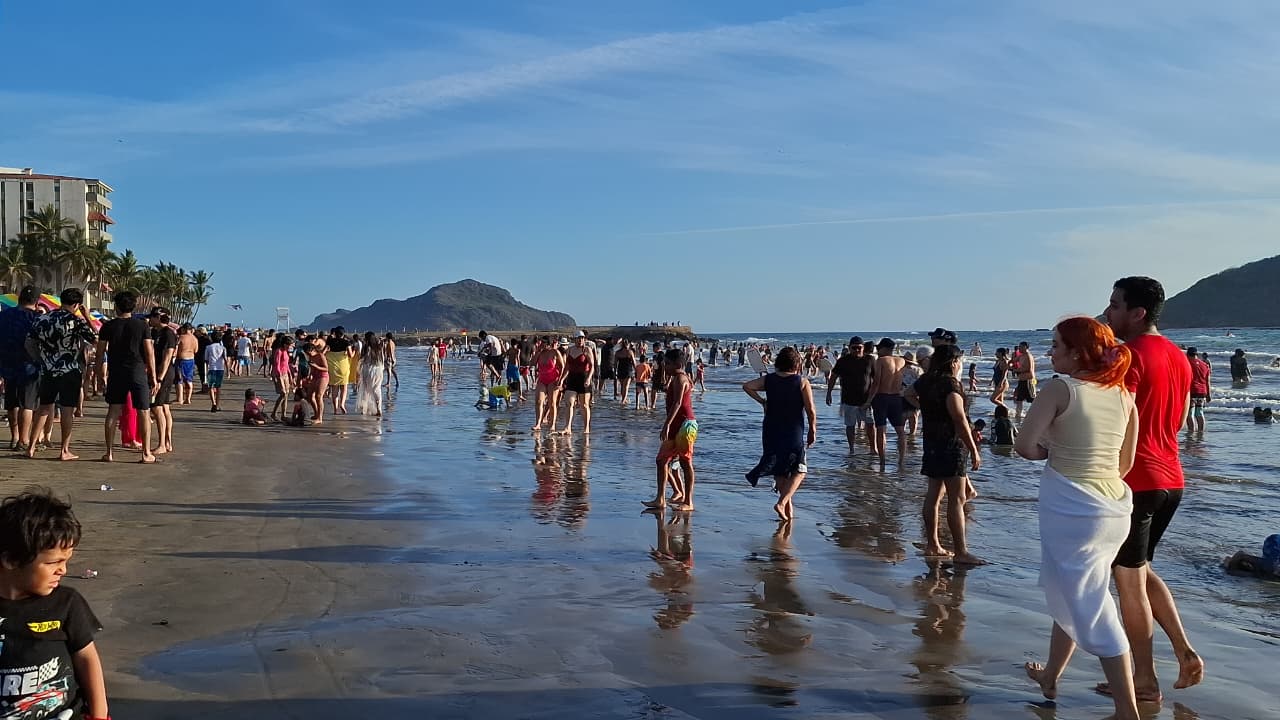 Personas caminando por la playa