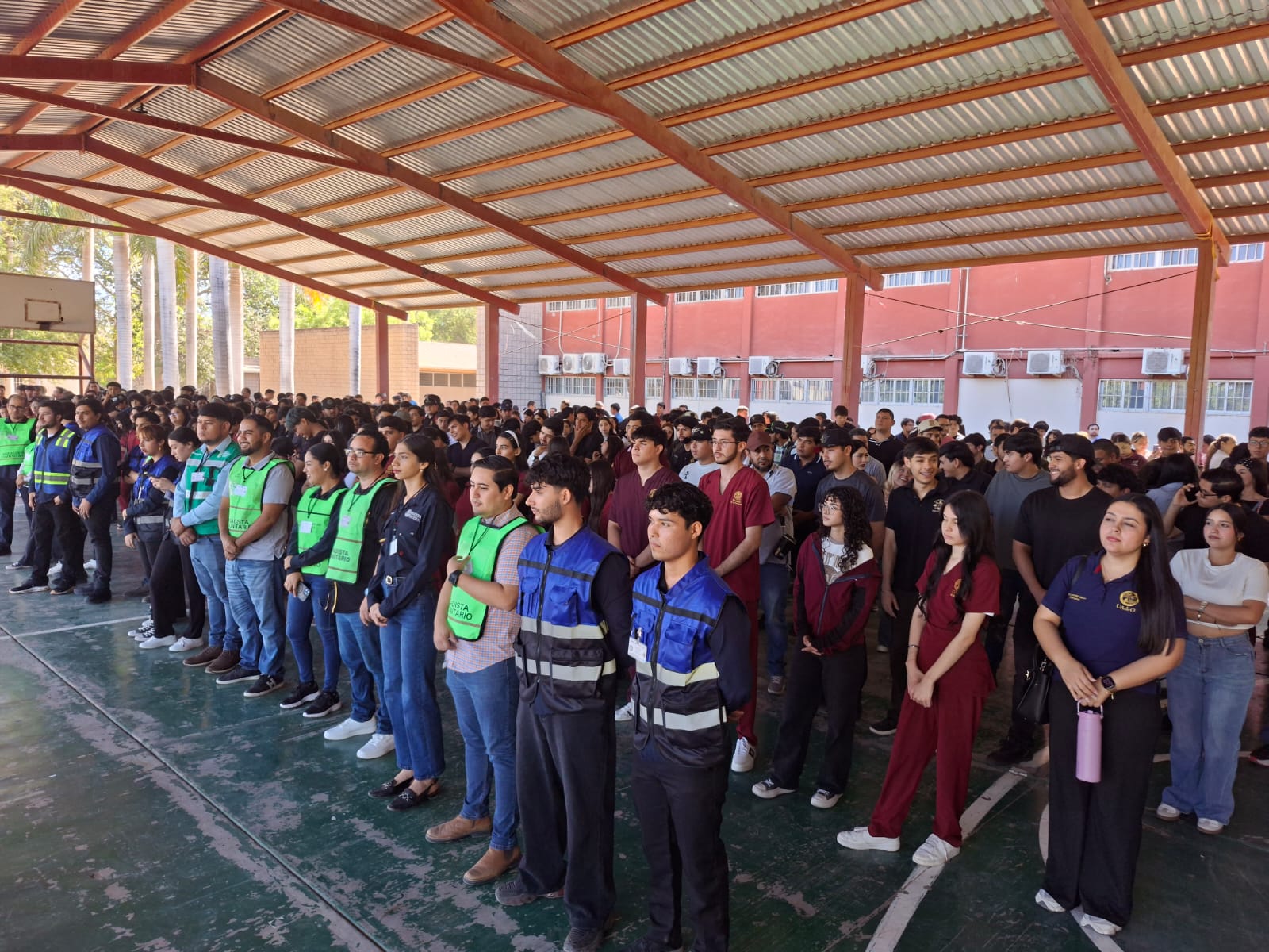 Personas bajo una techumbre en una escuela durante un simulacro