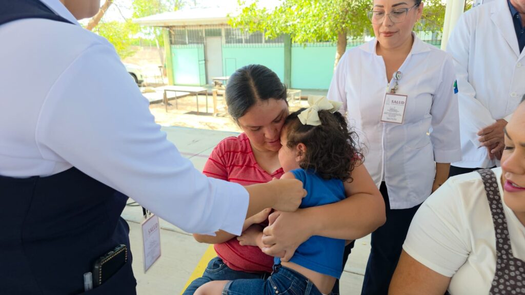 Menor de edad en los brazos de su mamá recibiendo una vacuna