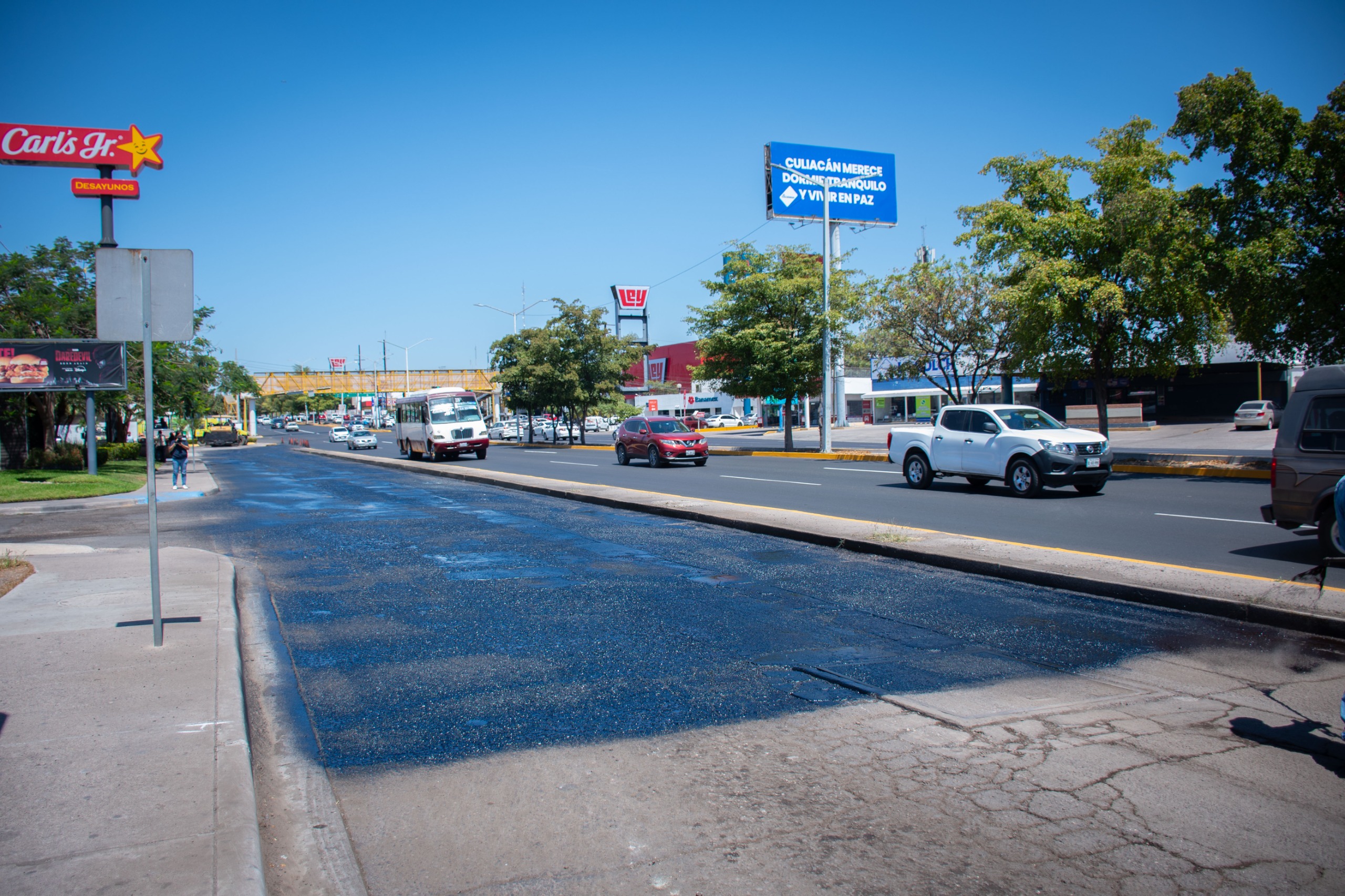 Calle con reparación y reencarpetado con carros transitando