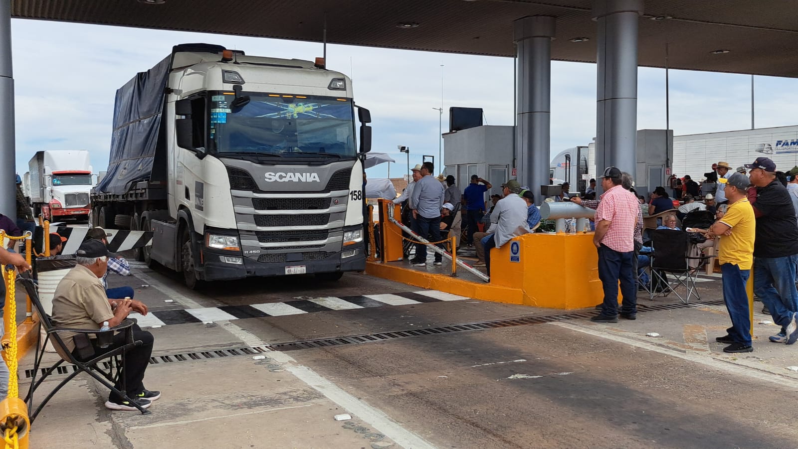 Caseta de peaje con un camión de carga y personas