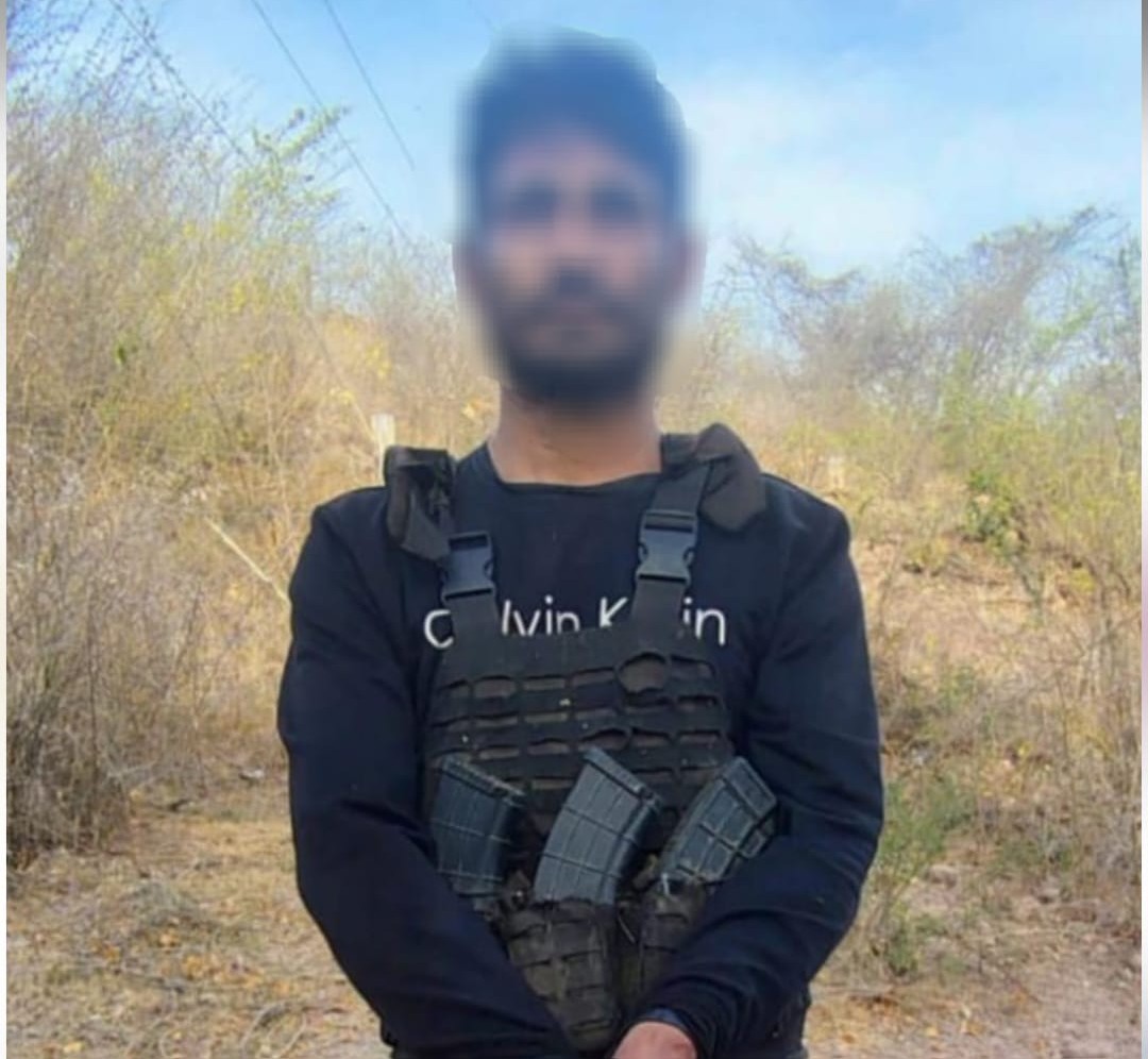 Hombre detenido vestido de negro con chaleco antibalas