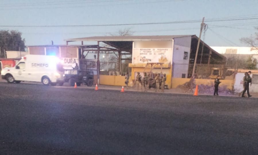 Elementos de seguridad y unidades en una calle frente a un establecimiento