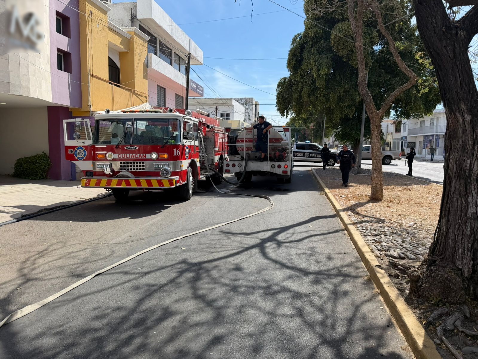 Unidad de bomberos en una calle y elementos de emergencia desplegados en el área
