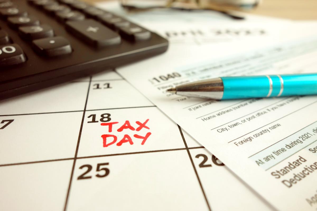 Calendario con el TAX DAY y una pluma y una calculadora