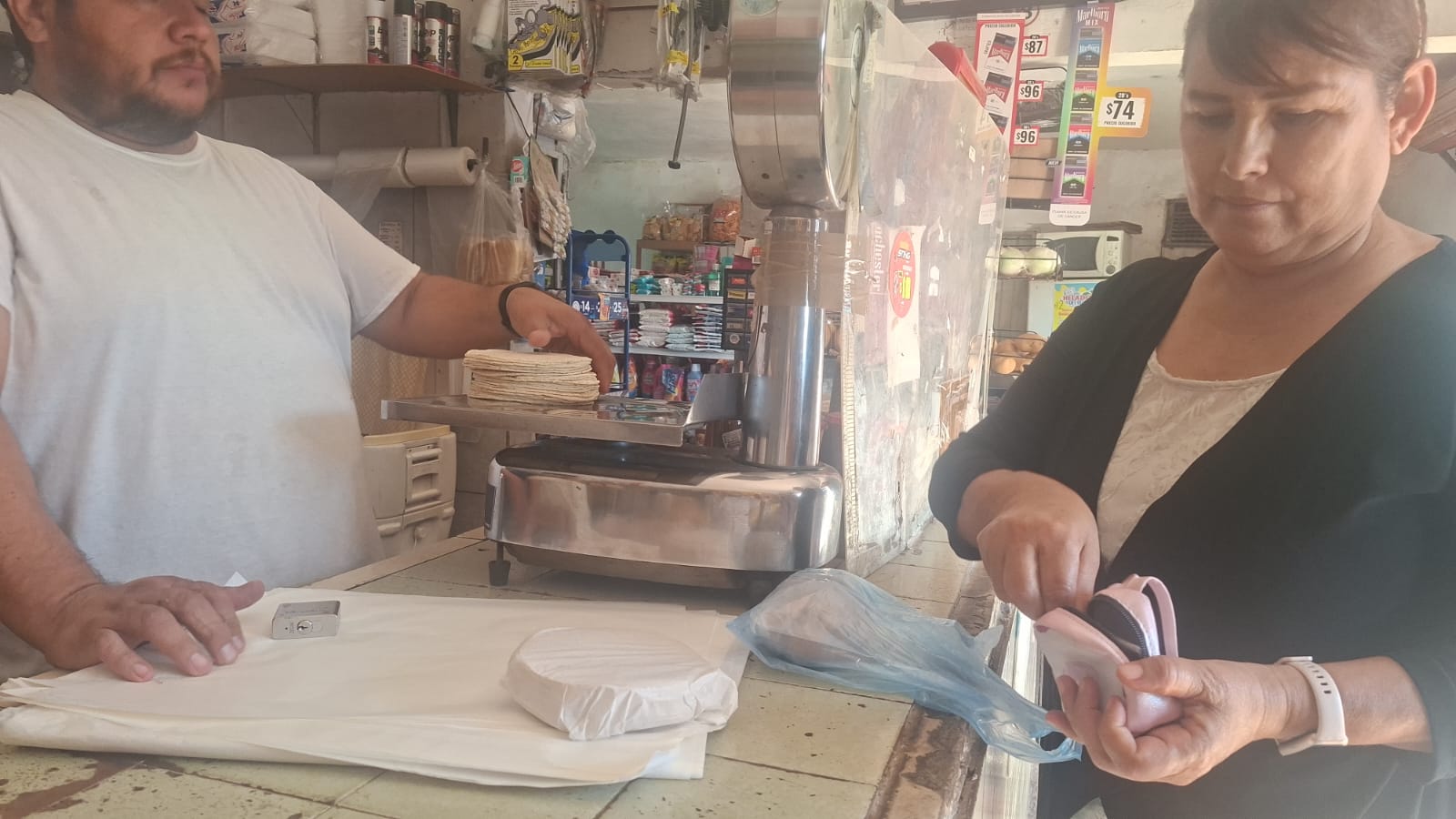 Mujer comprando tortillas en una tienda de abarrotes
