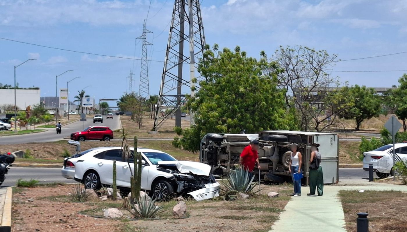 Carro de color blanco con un impacto en la parte frontal y una unidad de carga volcada cerca de in parque