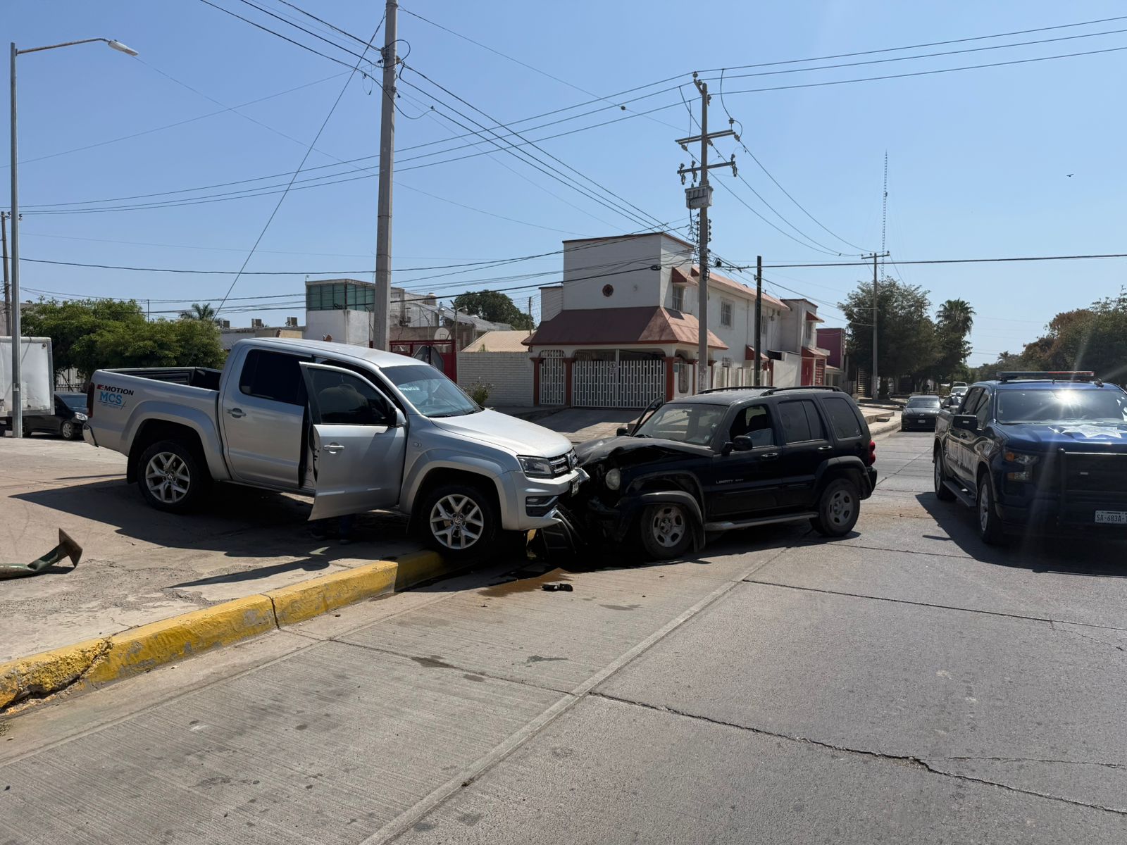 Camionetas chocadas de frente sobre banqueta