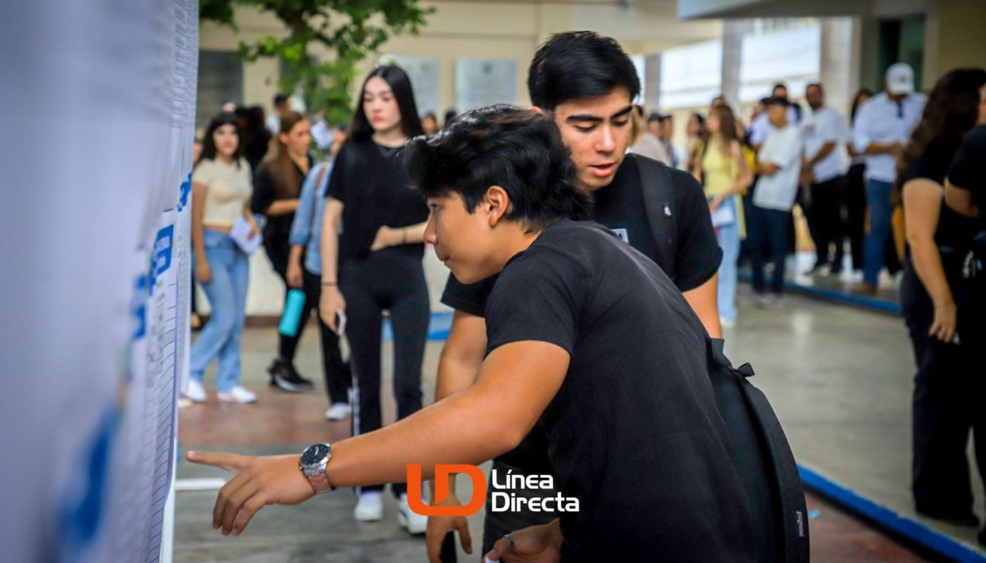 Jóvenes junto a un listado en una escuela