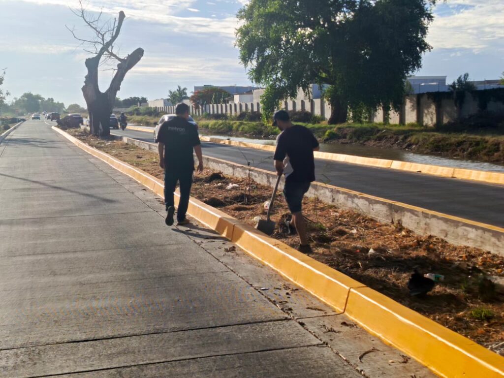 Dos personas limpiando camellón en Los Mochis