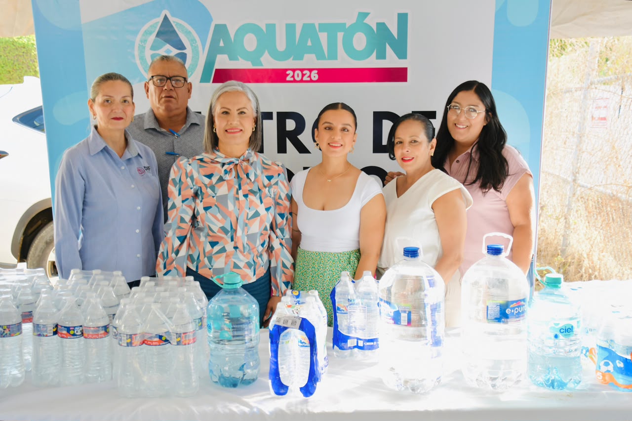 Personas sonriendo para foto y mesa con botellas de agua