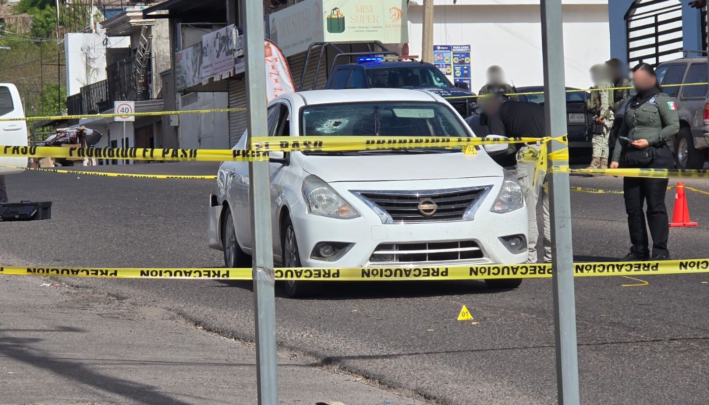 Auto baleado en medio de la calle asegurada y elementos de seguridad e investigación en la zona