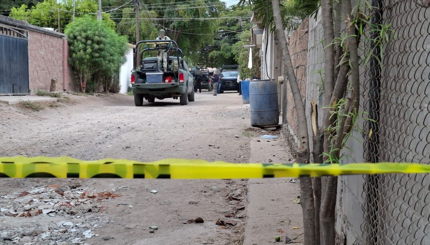 Unidades y elementos policiacos en una calle de terracería con una cinta amarilla de precaución