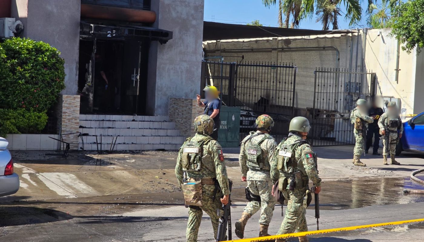 Elementos del ejercito mexicano y bomberos a las afueras de un establecimiento vandalizado