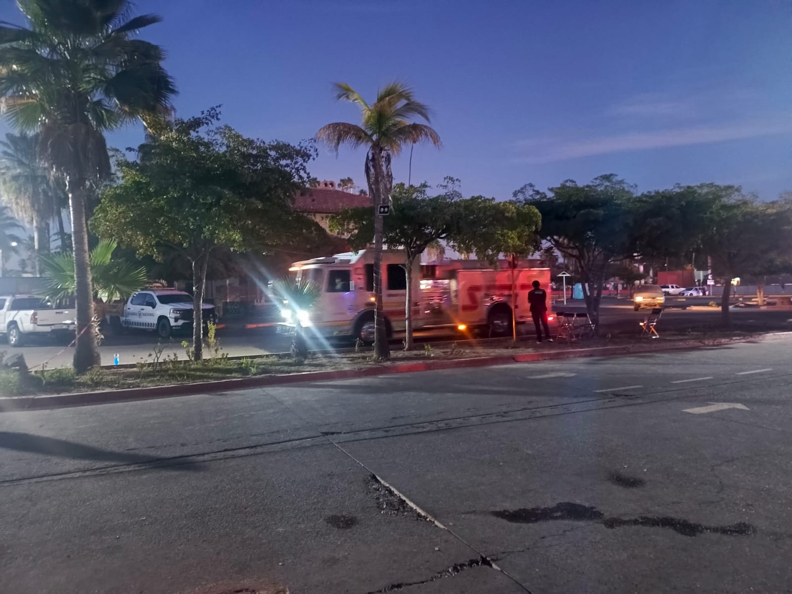 Bomberos en la calle junto a plaza quemada en Los Mochis