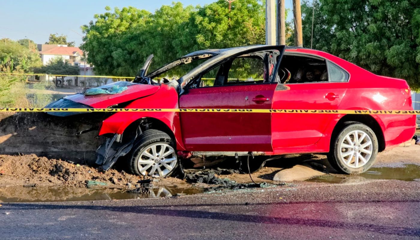 Carro rojo con un impacto por choque en la parte frontal y una cinta amarilla de precaución resguardando la zona