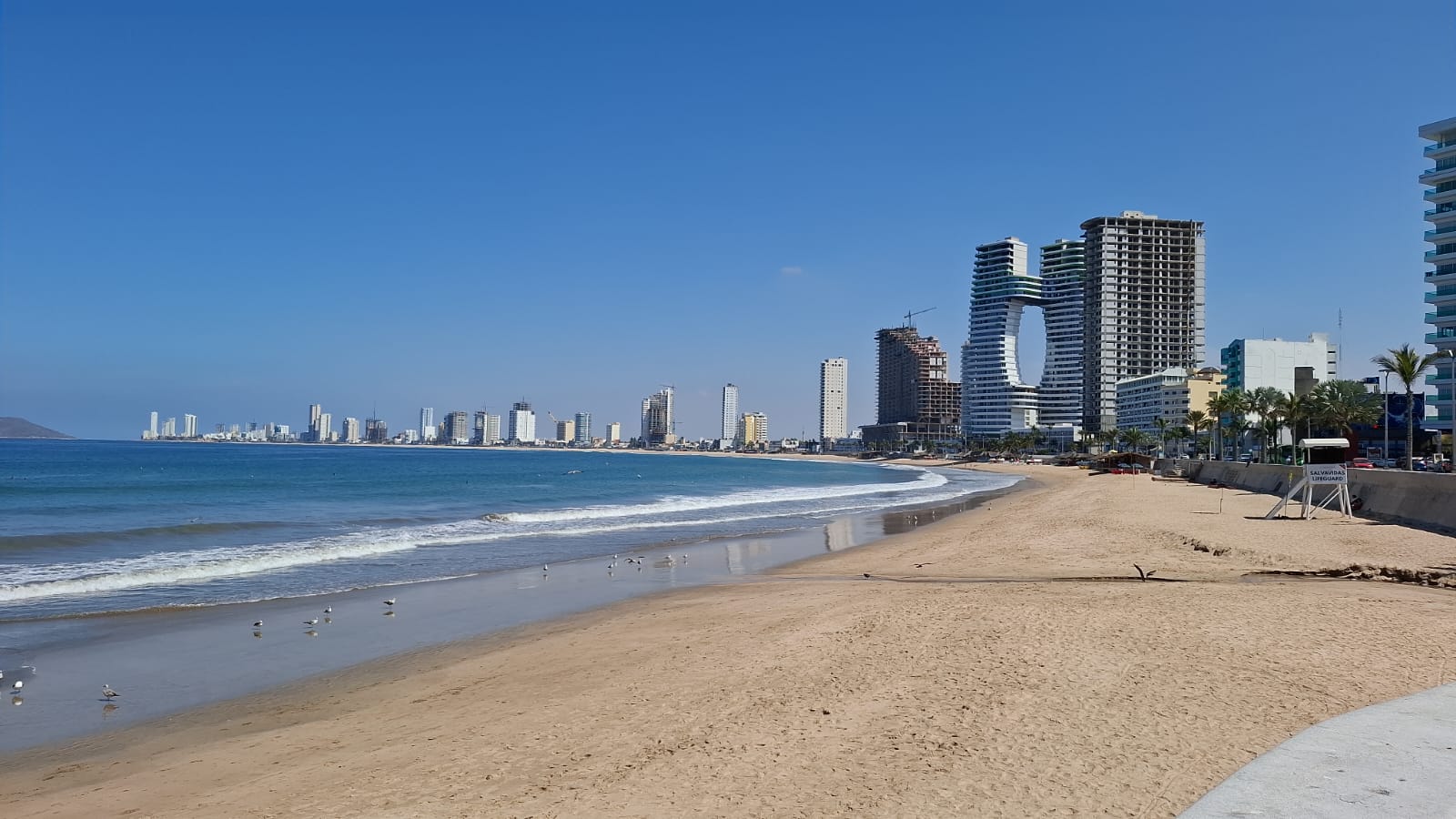 playa con edificios al fondo y cielo soleado
