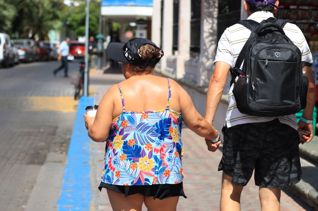 Turistas caminan por una zona turística de Mazatlán durante una jornada soleada y calurosa, mientras Sinaloa enfrenta temperaturas de hasta 45 °C, oleaje elevado y probabilidad de lluvias aisladas.