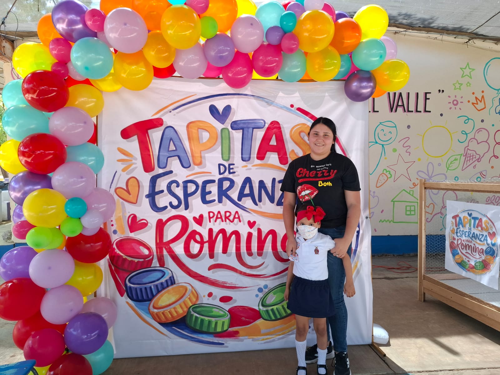 Globos junto a una persona adulta y una niña con cubrebocas