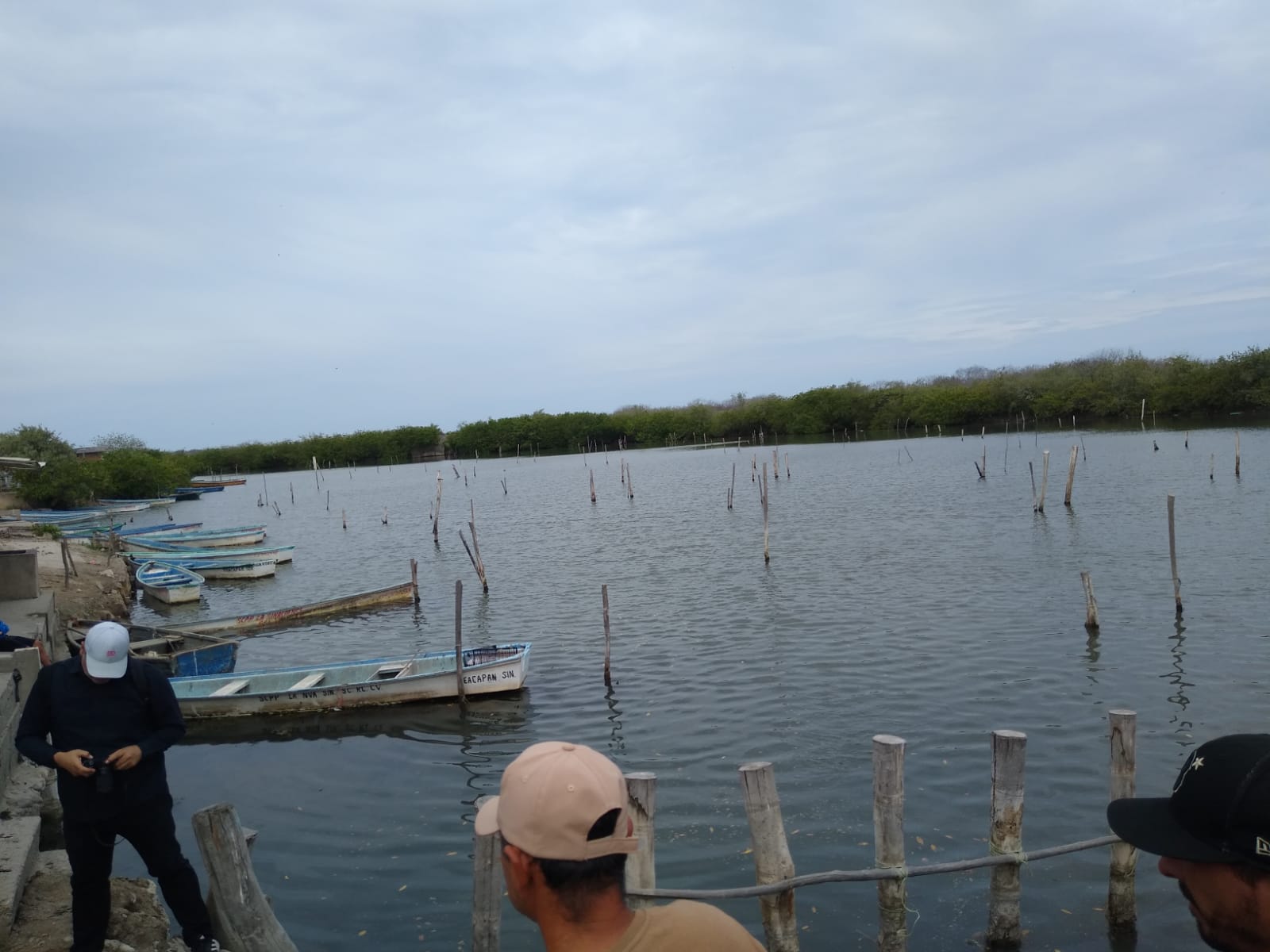 Sistema lagunar, pescadores a la orilla y dentro lanchas