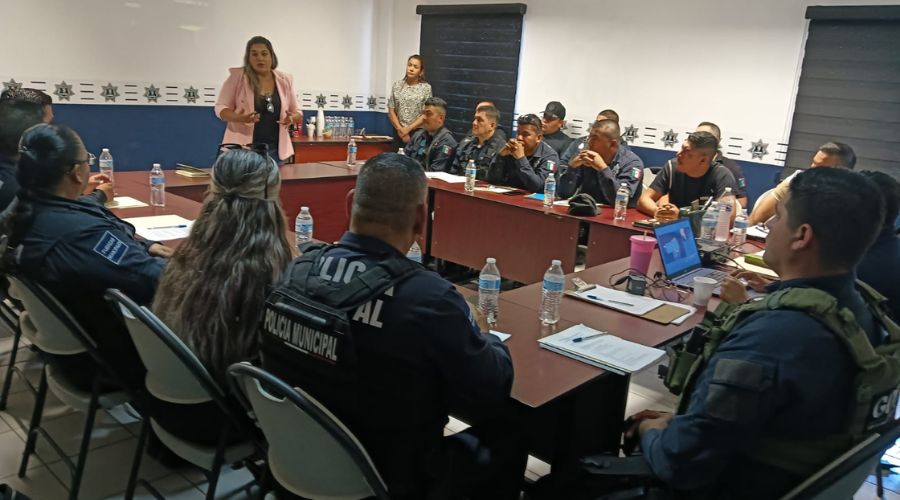 Policías sentados en una mesa recibiendo capacitación