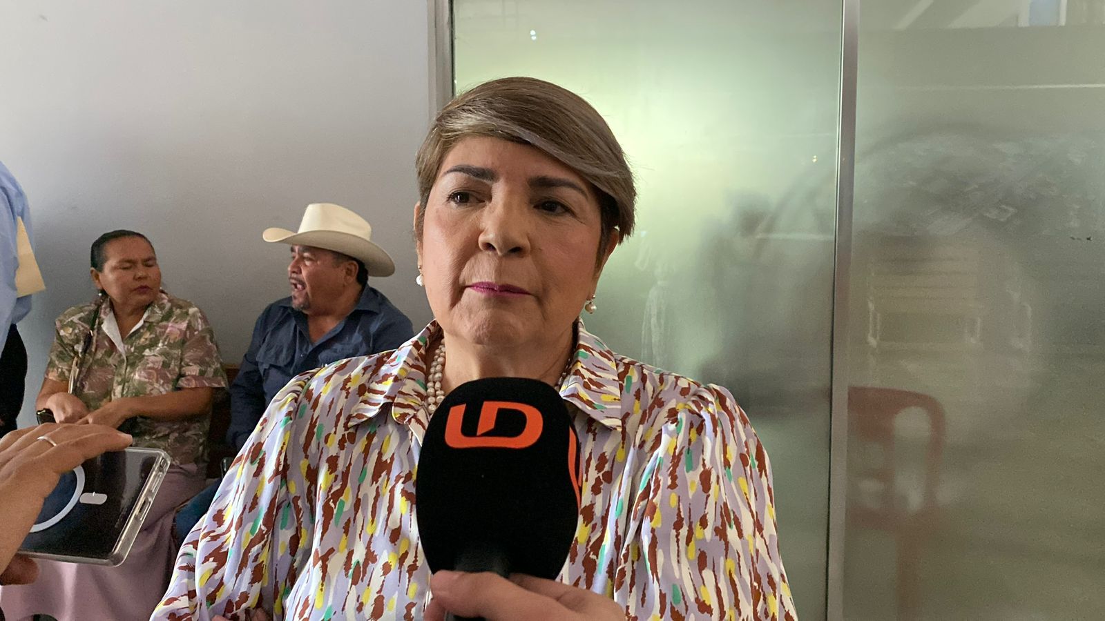 Mujer hablando por micrófono de Línea Directa