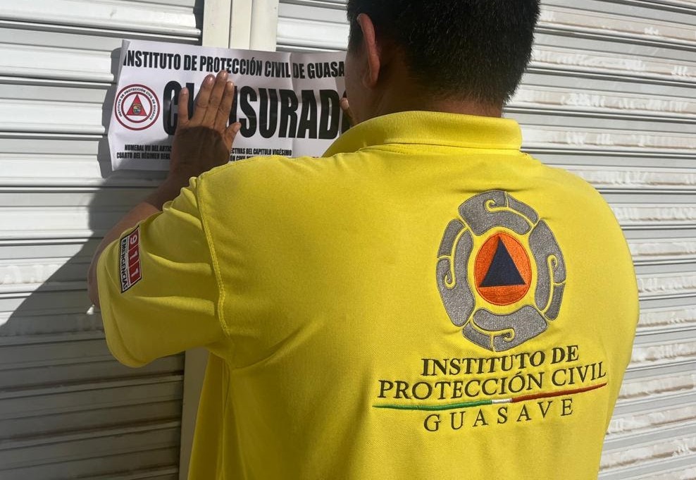 Personas de protección civil colocando un letrero de clausurado
