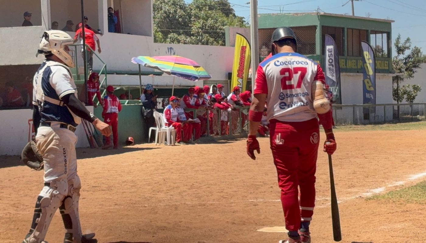 Jugador llegando a la caja de bateo y catcher por detrás