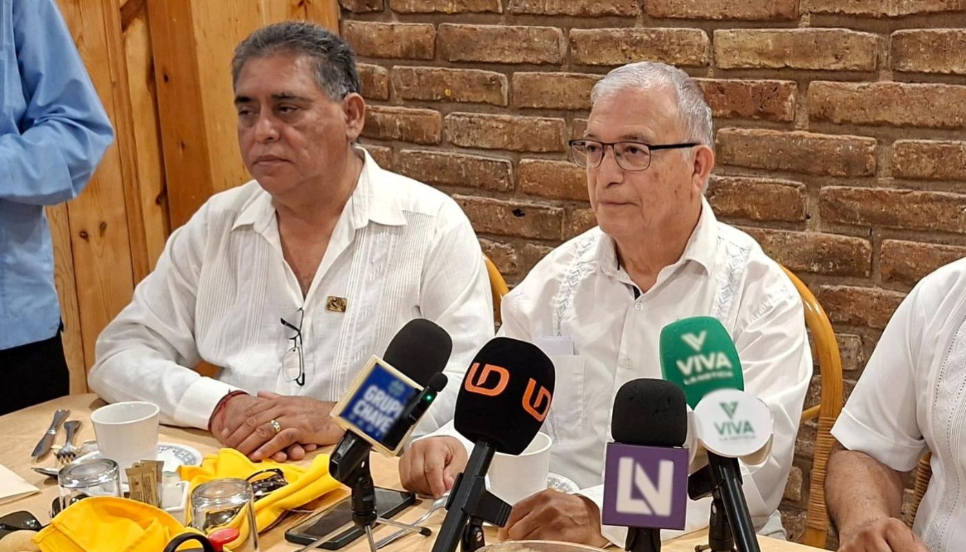 PErsonas en una rueda de prensa con micrófonos