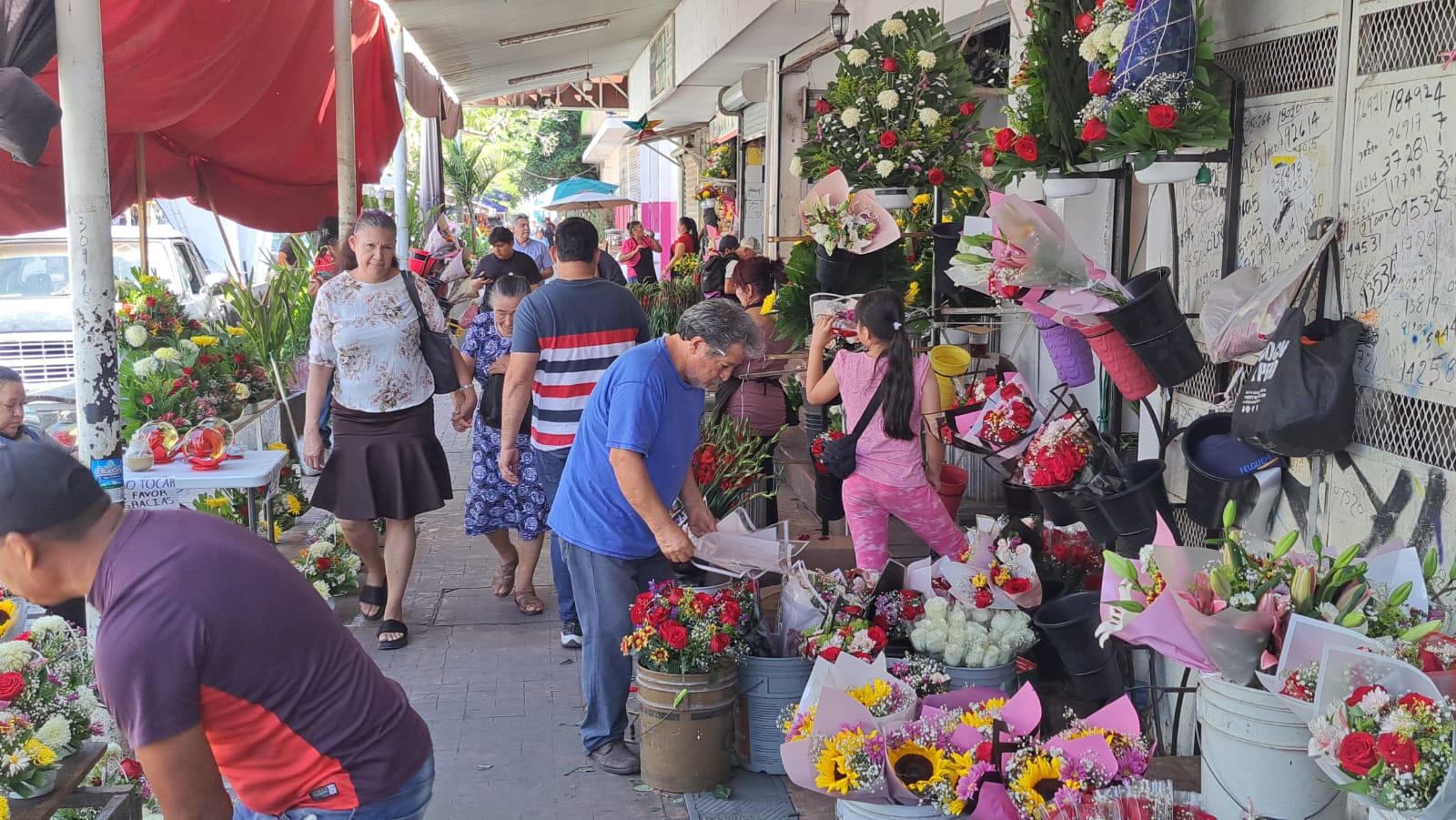 Personas transitando por zona comercial de flores