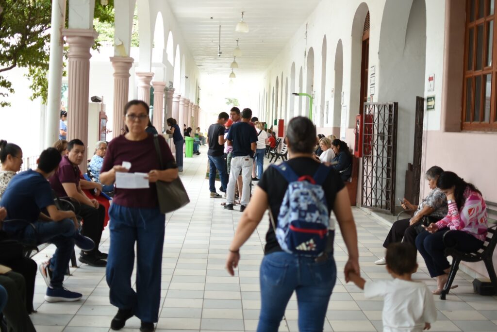 Personas caminando por un pasillo en edificio de la UAS