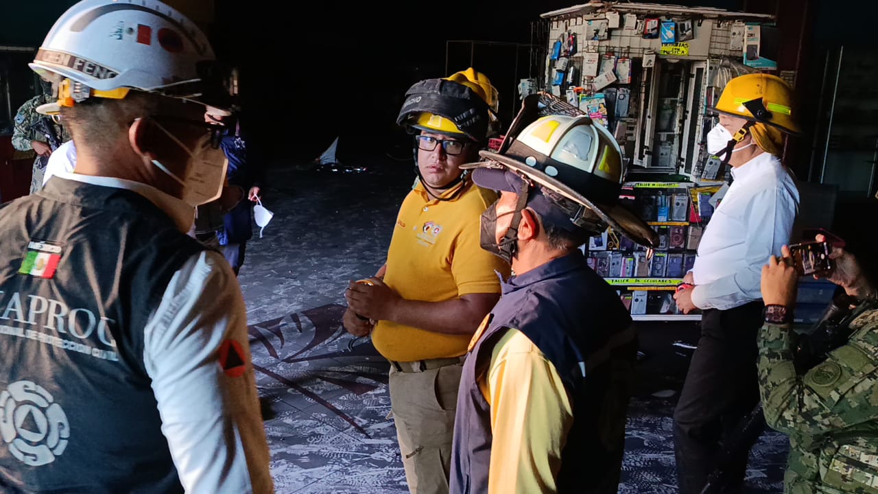 Personal de emergencias dentro de la plaza comercial incendiada en Los Mochis