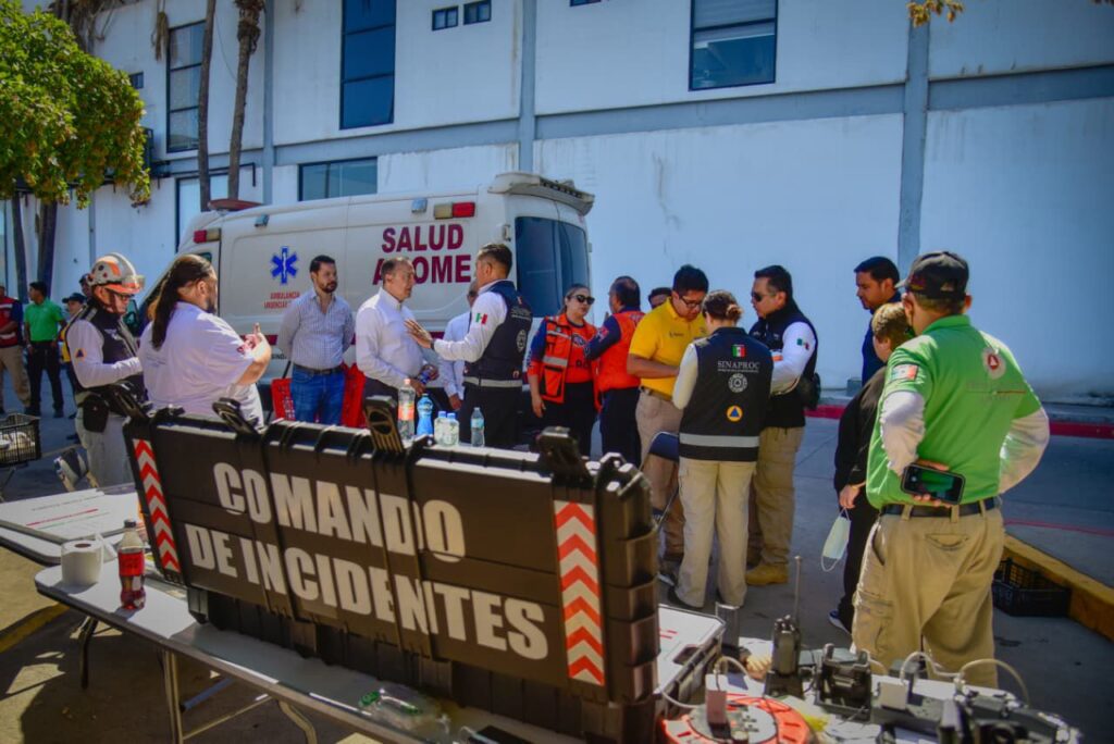 Cuerpos de emergencia junto a un botiquín junto a una ambulancia