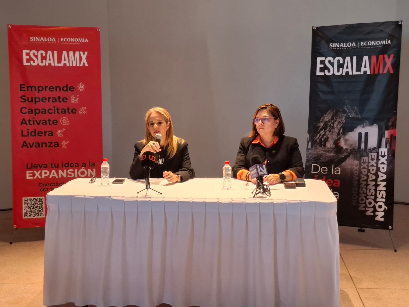 Mujeres sentadas detrás de mesa en conferencia