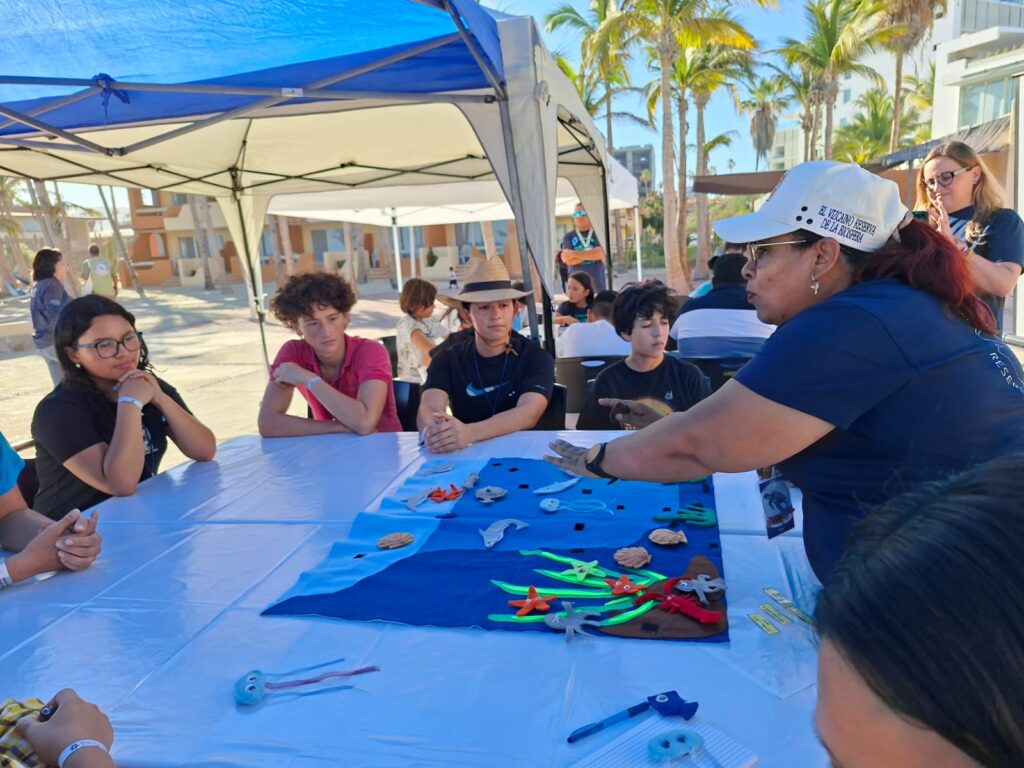 Personas en una mesa junto a una maqueta del mar