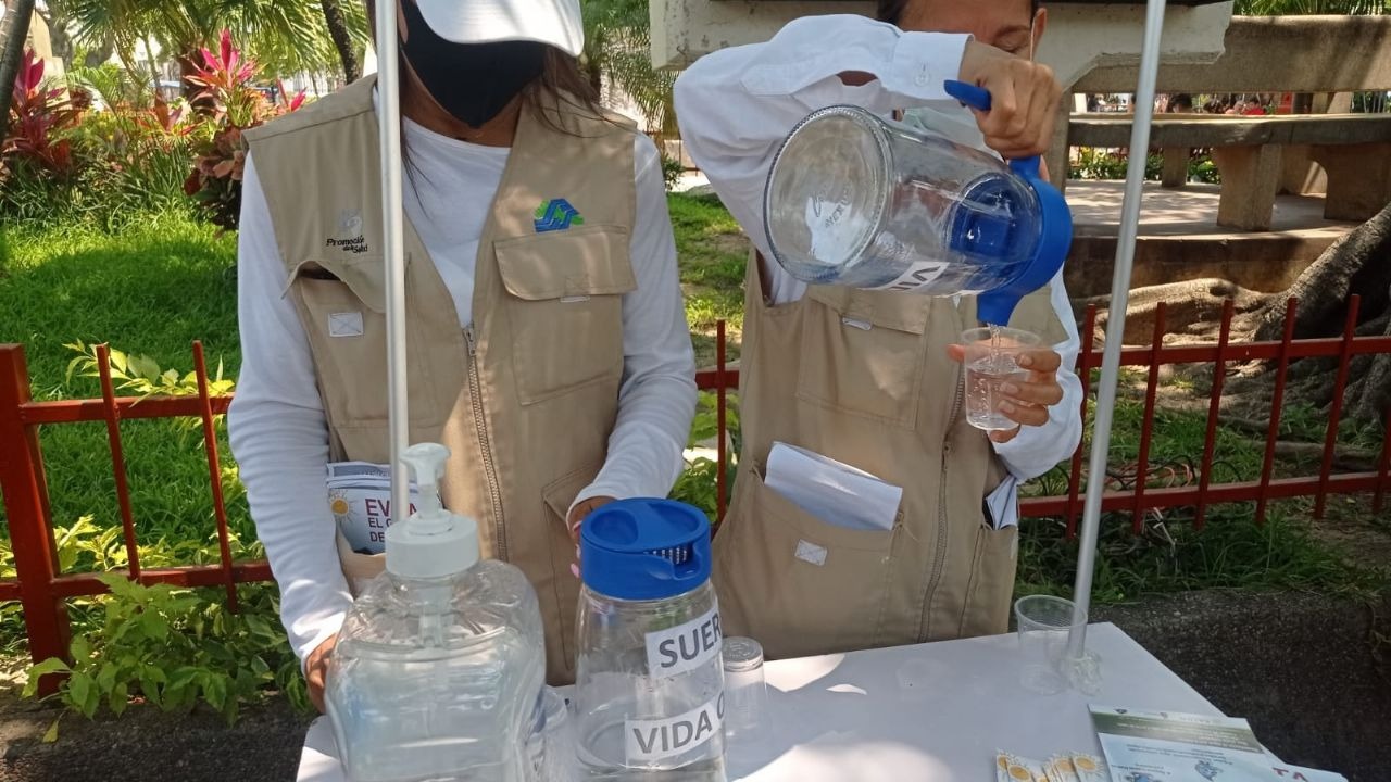 personas con camisa blanca y chaleco café sirviendo suero en vasos