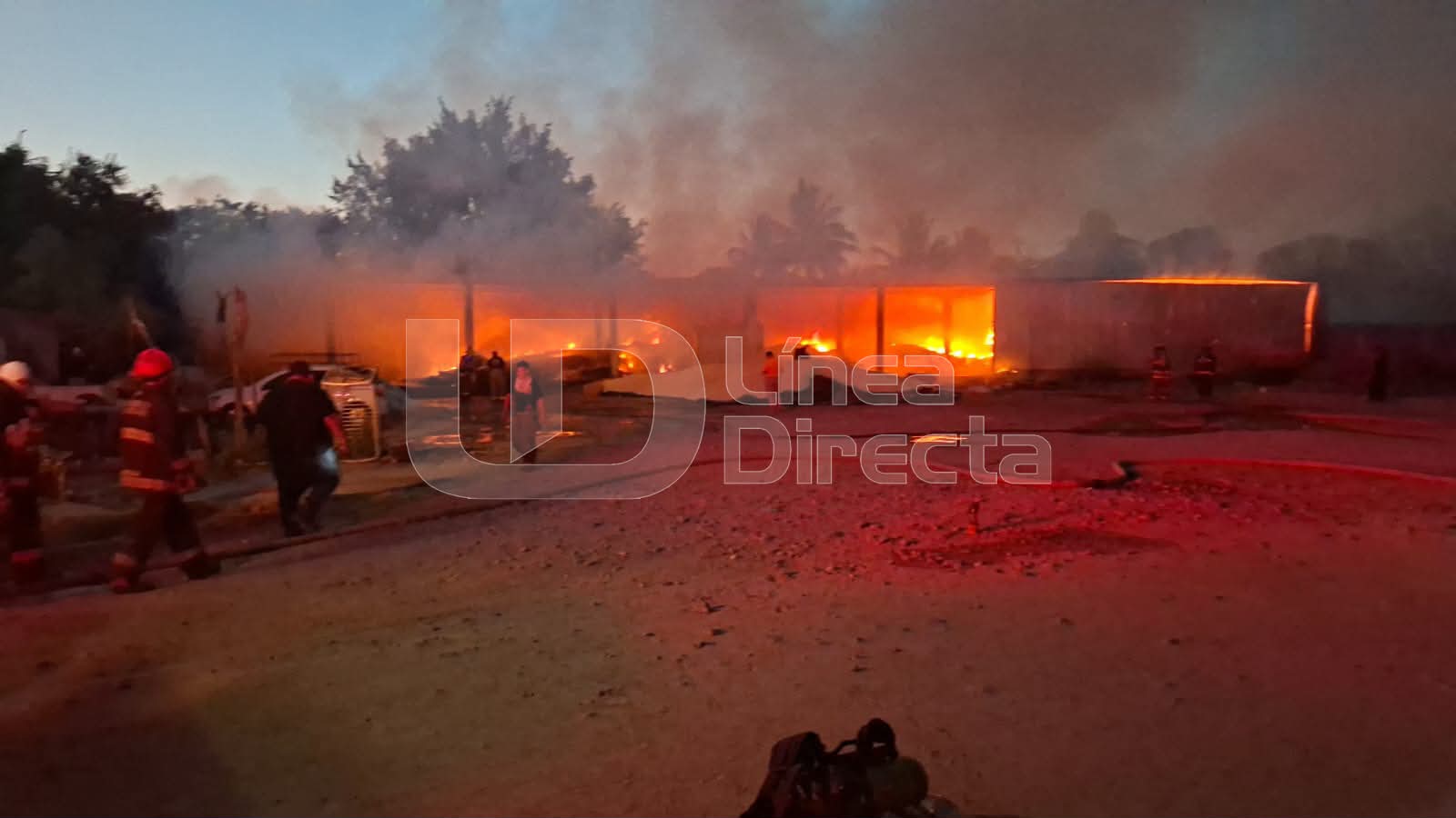 Campo con fuego naranja y humo junto a una marca de agua de Línea Directa