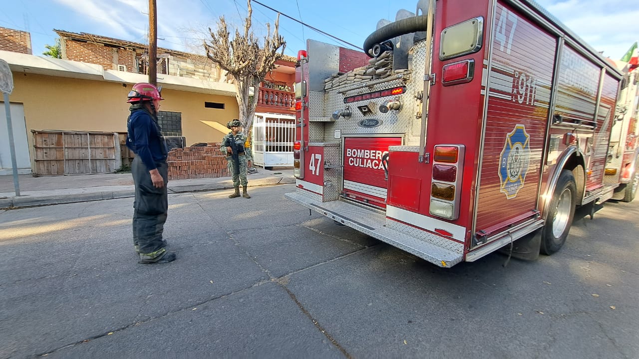 Camión de bomberos color rojo junto a un elementos