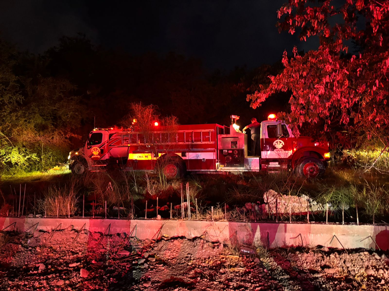 Camión de bomberos en la obscuridad junto humo en un incendio